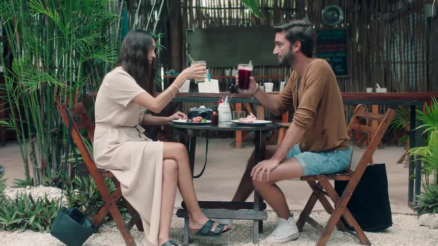 A man and woman dine together outside