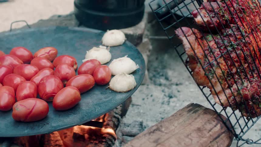 Food is cooking on an outdoor stove during the day