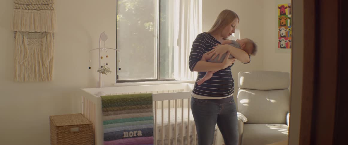A mother rocks and sings to a newborn