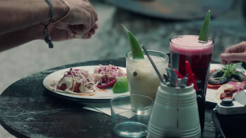 A man squeezes lime onto tacos