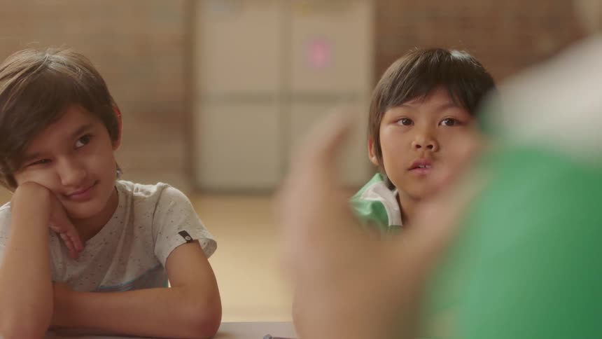 Children sit and listen to an adult