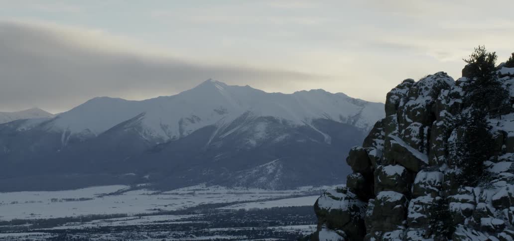 Snowy mountains on a cloudy day surrounding a valley