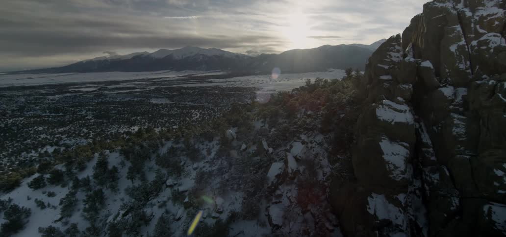 The sun sets over snowy mountains