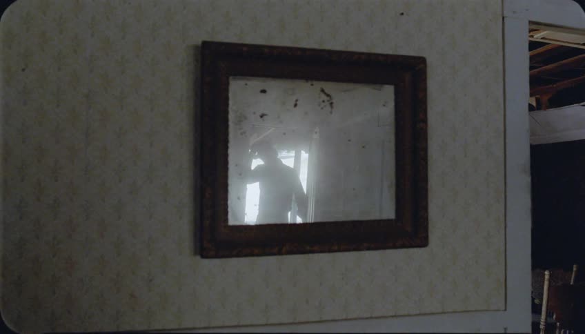 A man opens a front door and enters a home
