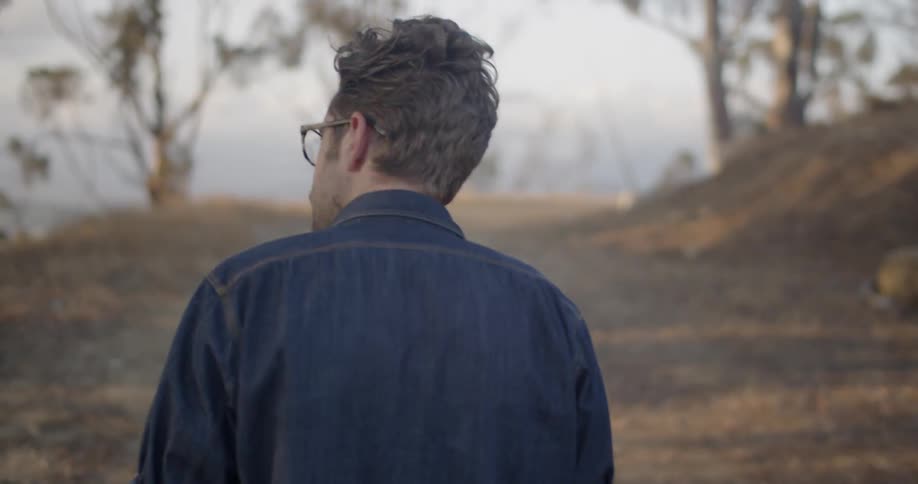 A man walking a trail points at something