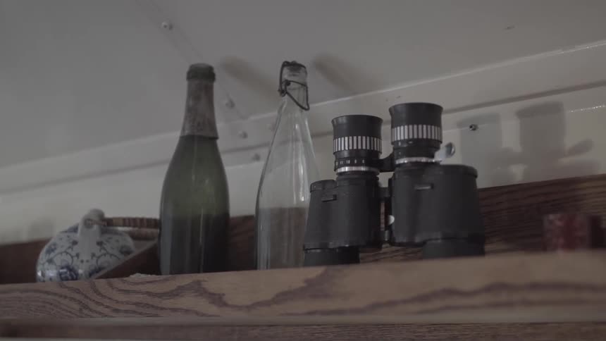 The shelf is lined with bottles and a binocular