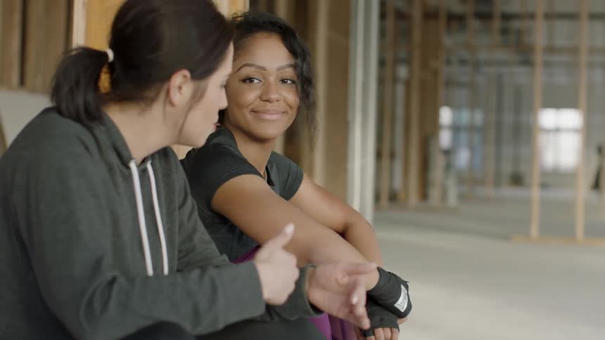 Two women sit in the hall smiling