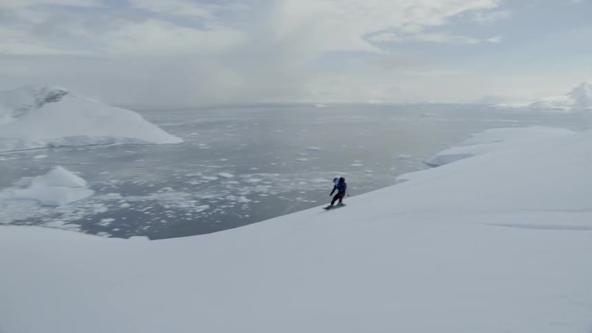 A person snowboards down the slope fast