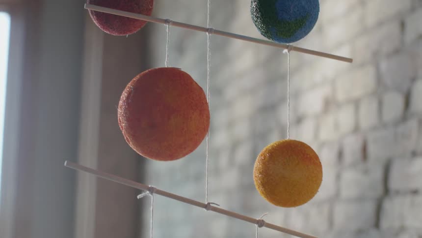 A planet mobile hangs from the ceiling