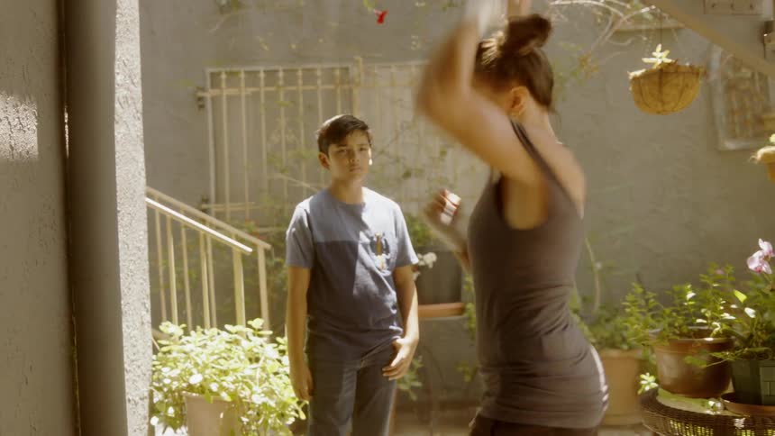 Woman practices punching and jabbing while a child watches