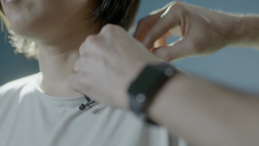 A microphone is attached to a woman's shirt
