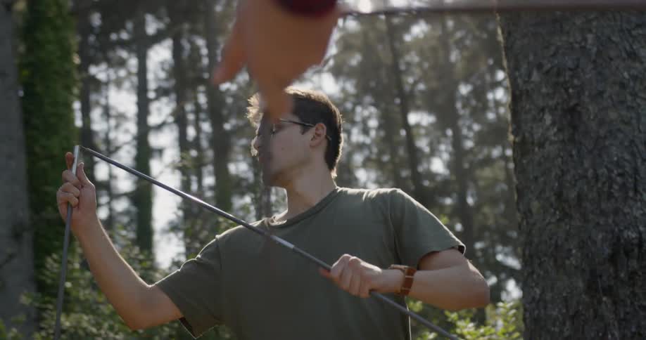 A man puts together the framing for a tent