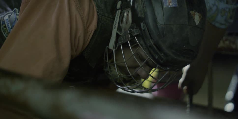 A man in a helmet is leaning forward working