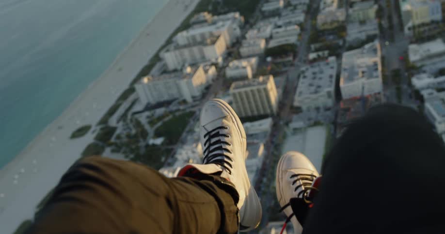 A man waves his legs while falling in a helicopter