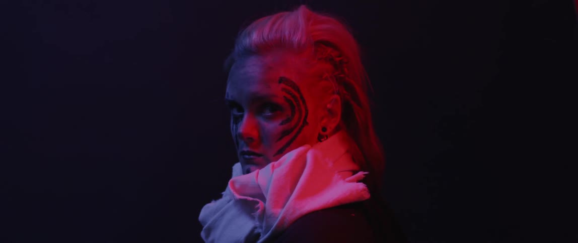 Woman with paint on her face looks over
