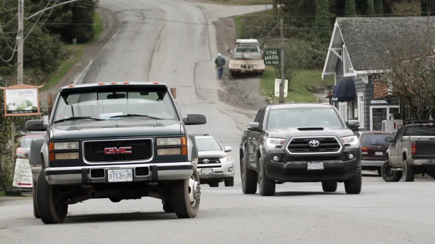 Vehicles drive on a town street