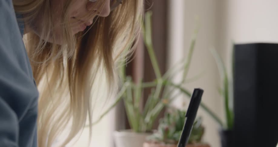 Female College Student Business Owner writes at a desk