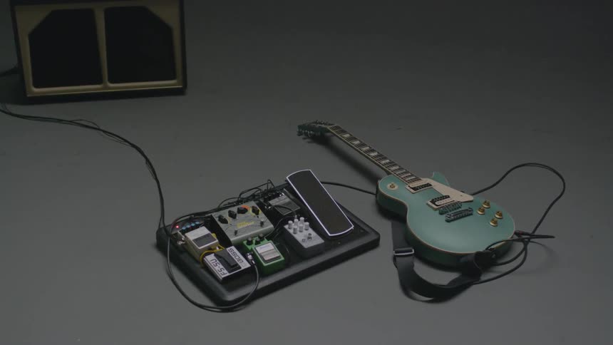 The guitar and amp are laying on the ground