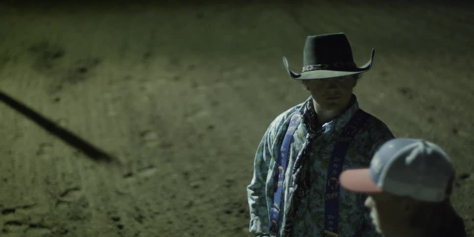 A rodeo crewman stands in the rodeo pen