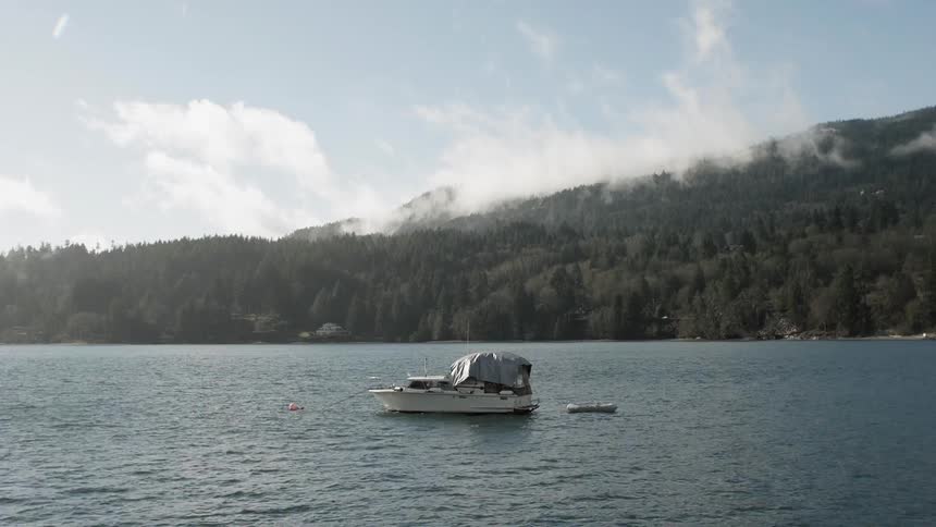 The tarp on an anchored boat blows in the wind