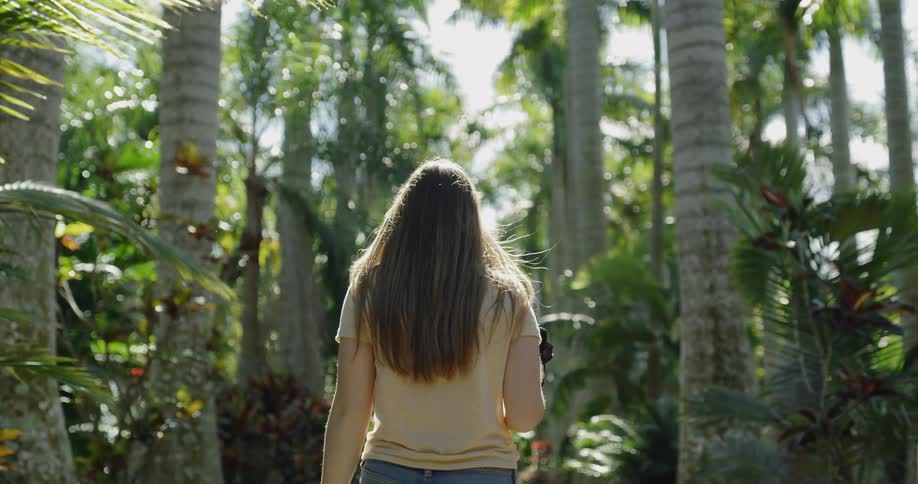 A woman is hiking in the forest with a camera