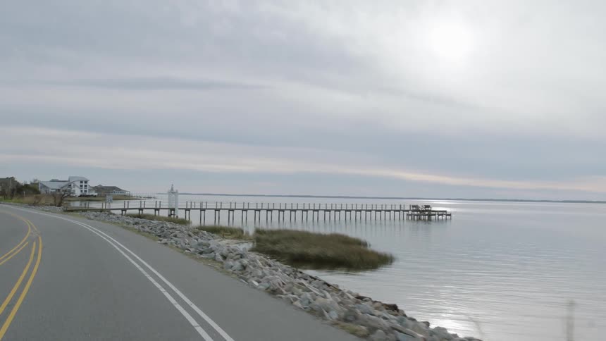 A car drives alongside a lake