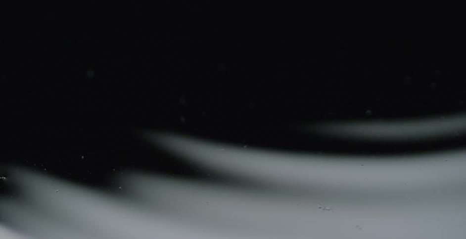 Ripples form on a black liquid surface