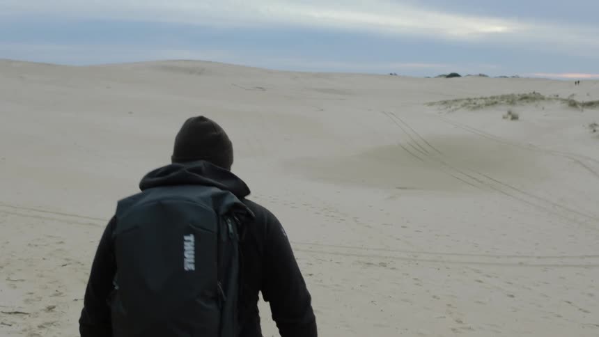 Person backpacks through a cloudy desert