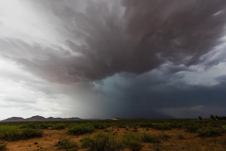 Storm clouds and rain over a field