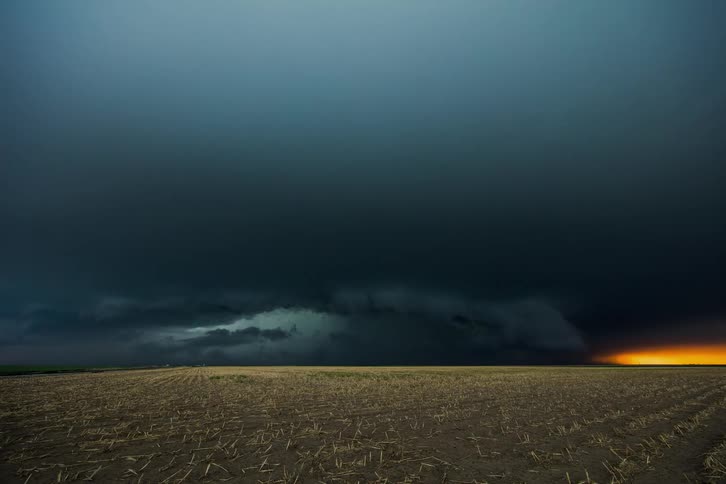A storm brews over an open field