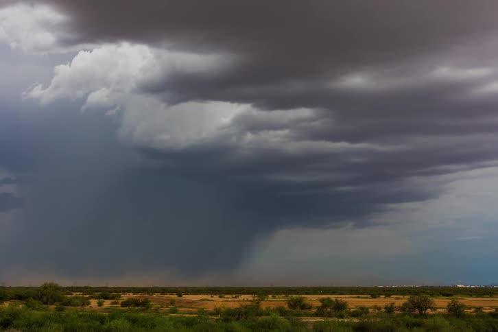 A storm brews over an open field