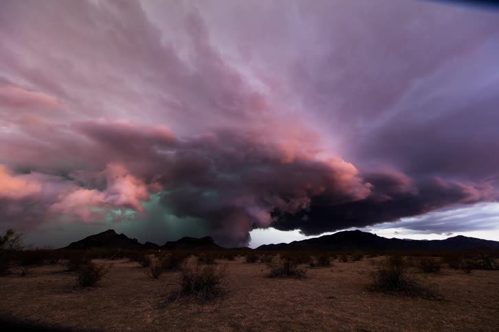A storm brews over some hills