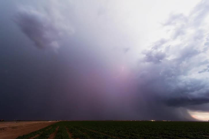 A storm brews over an open field