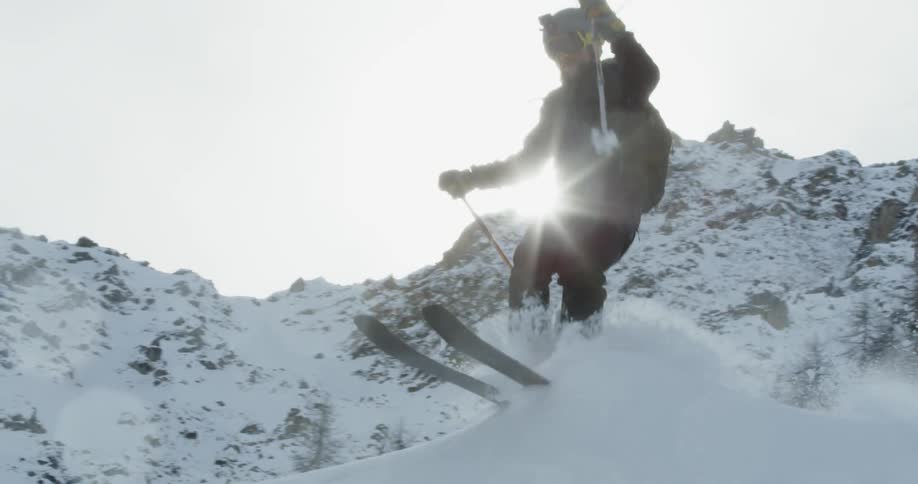 A man does a jump over a snow hill on his skis