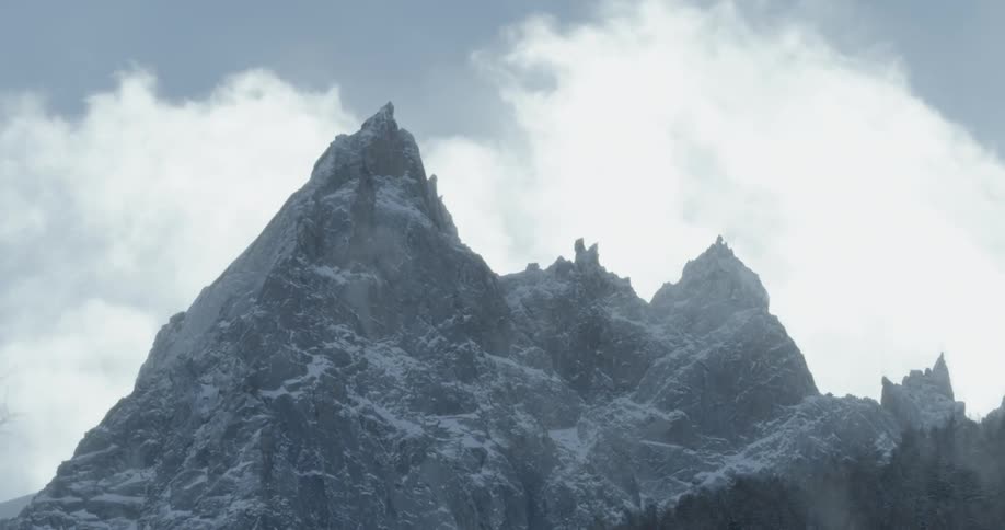 Time-lapse of clouds passing some pointed mountains