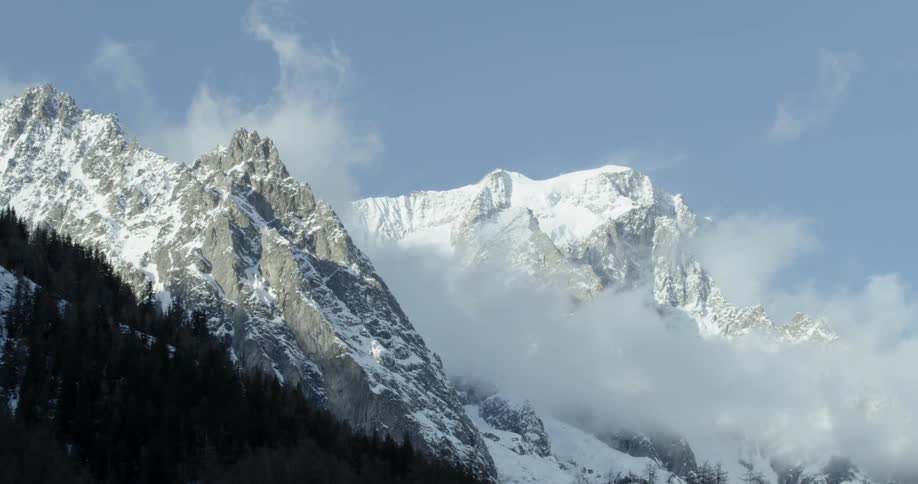 Clouds are drifting through a mountain pass on a winter day