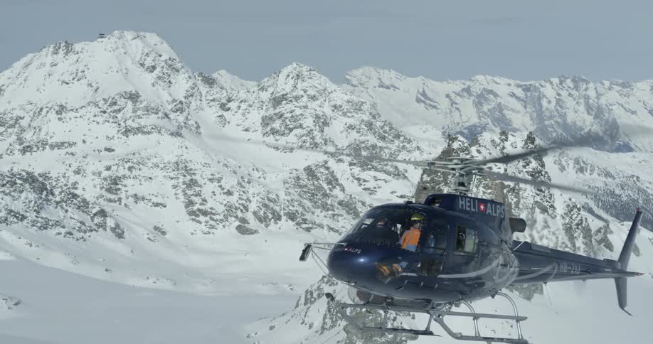 A helicopter is landing in the snowy mountains