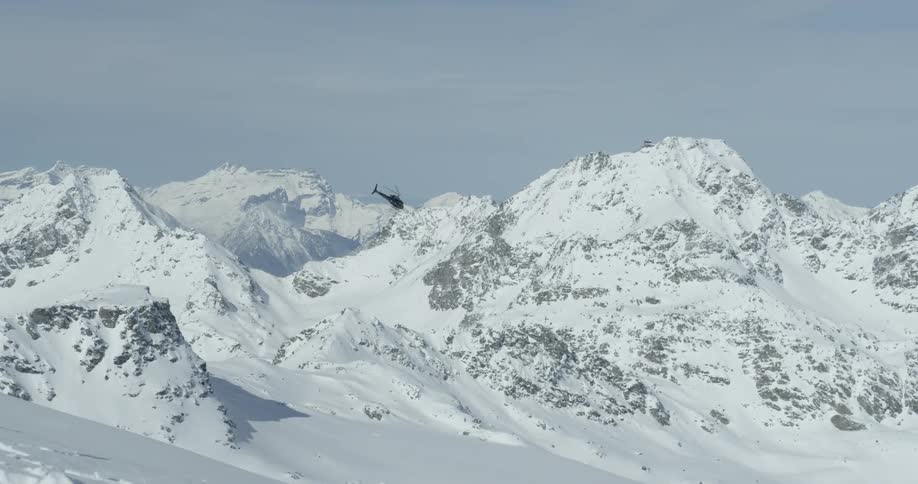 AStar helicopter flies above snow covered mountains in europe