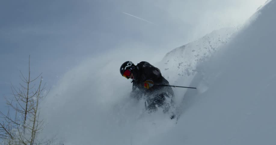 A person turns in the snow as he descends down the slope