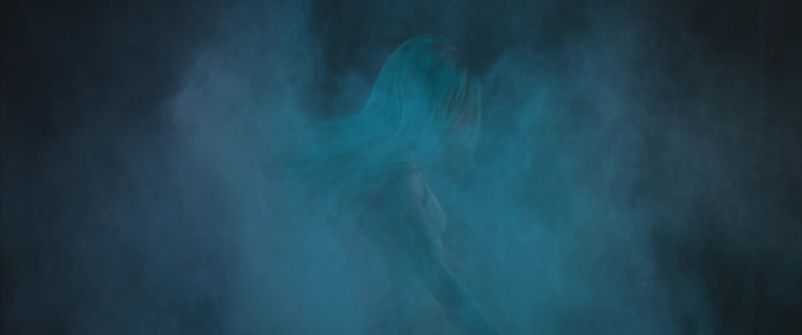 A woman twirling around in a cloud of dust