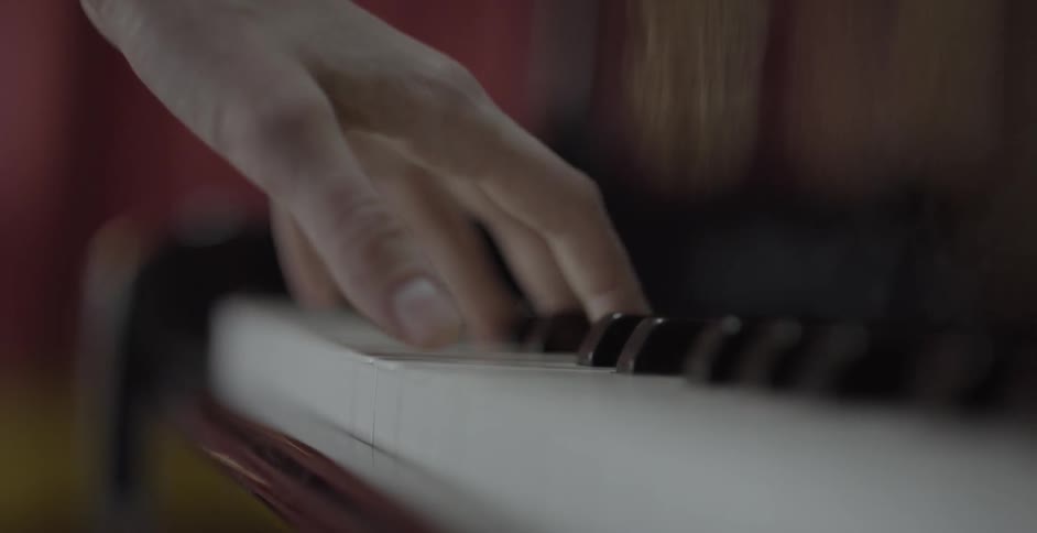 Woman striking several piano keys at the same time