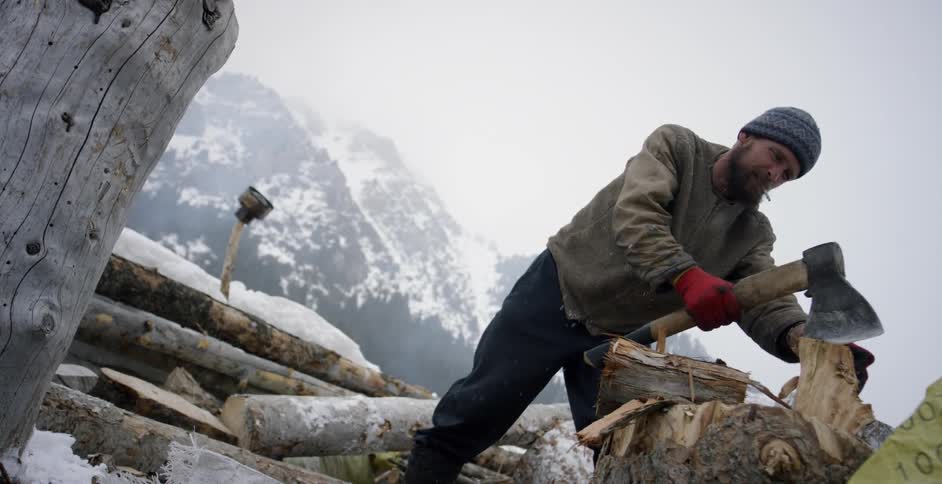 A man chops firewood with a hatchet