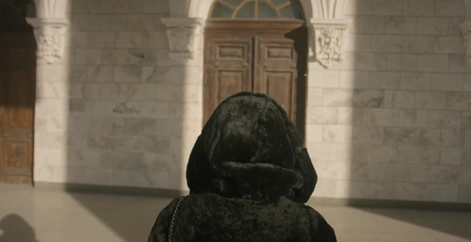 A woman approaches the door to a large building