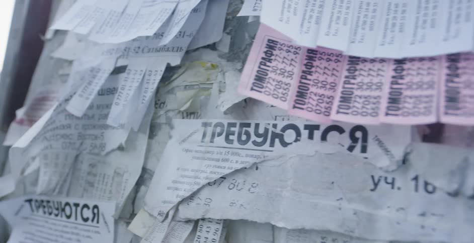 Paper advertisements on a billboard in the city