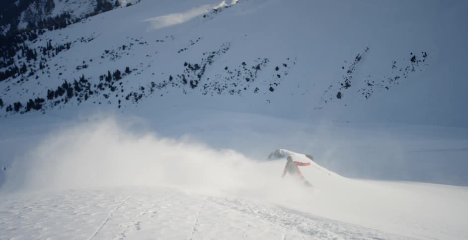 Person skis down the side of a snowy mountain