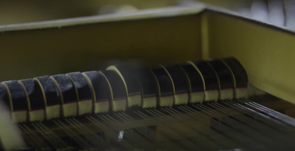 Inside a piano as keys are played and hit the strings