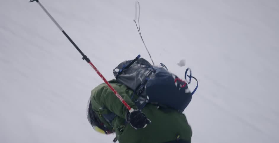 Person skis down a steep mountain spinning around