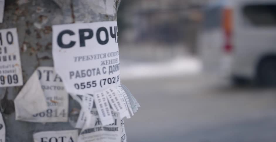 The pole is covered with paper advertisements