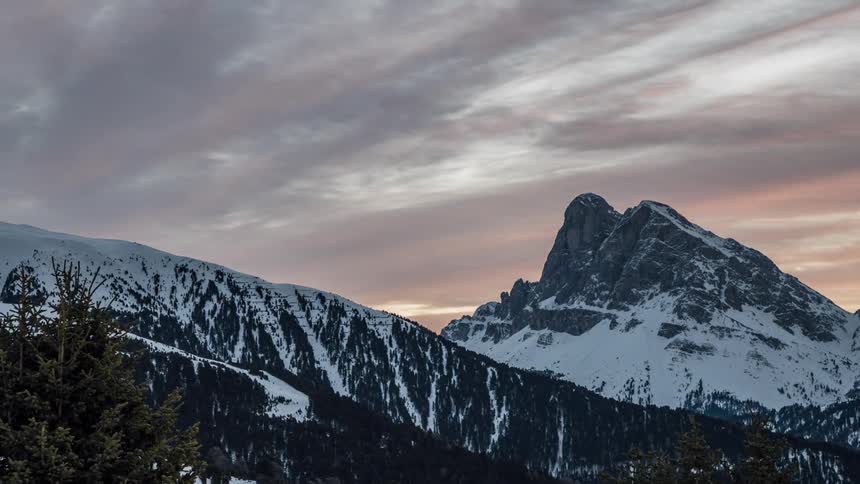 Dark clouds float over a snow covered mountain