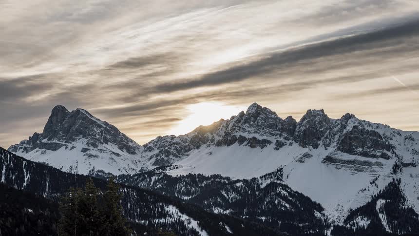 Clouds float over a snowy mountain range